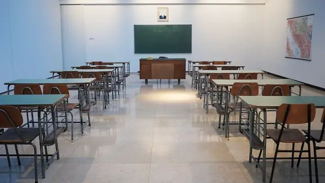 A photo of an empty classroom with desks and chairs