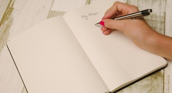 Girl writing her plans on a notebook