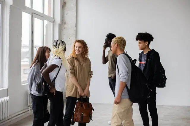 A photo of a few friends standing inside of a university building