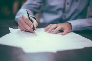 Person signing an agreement for a student loan refinance with cosigner
